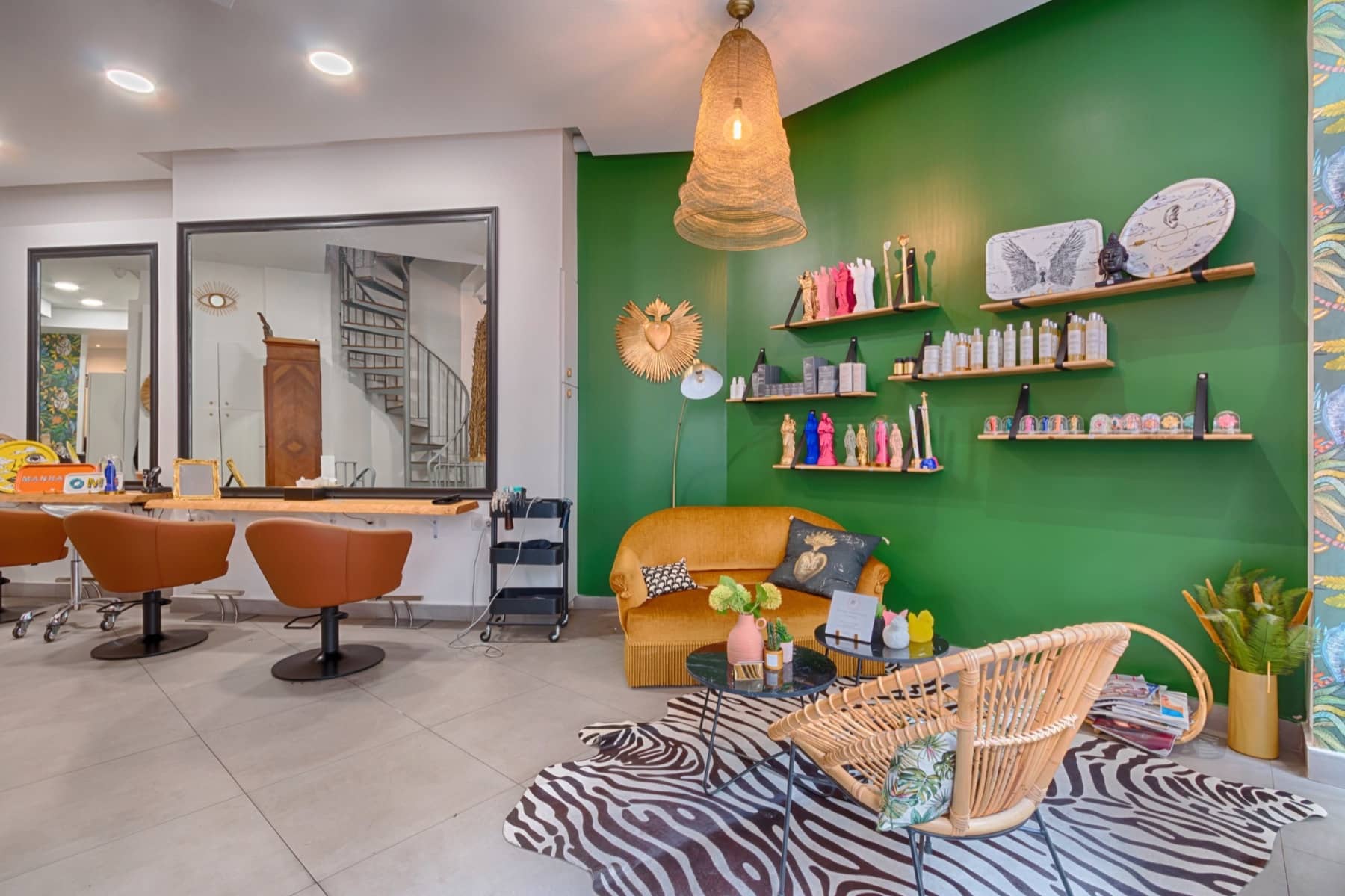 Le salon : mur vert profond, canapé velours moutarde, fauteuils cuir cognac et tapis zèbre