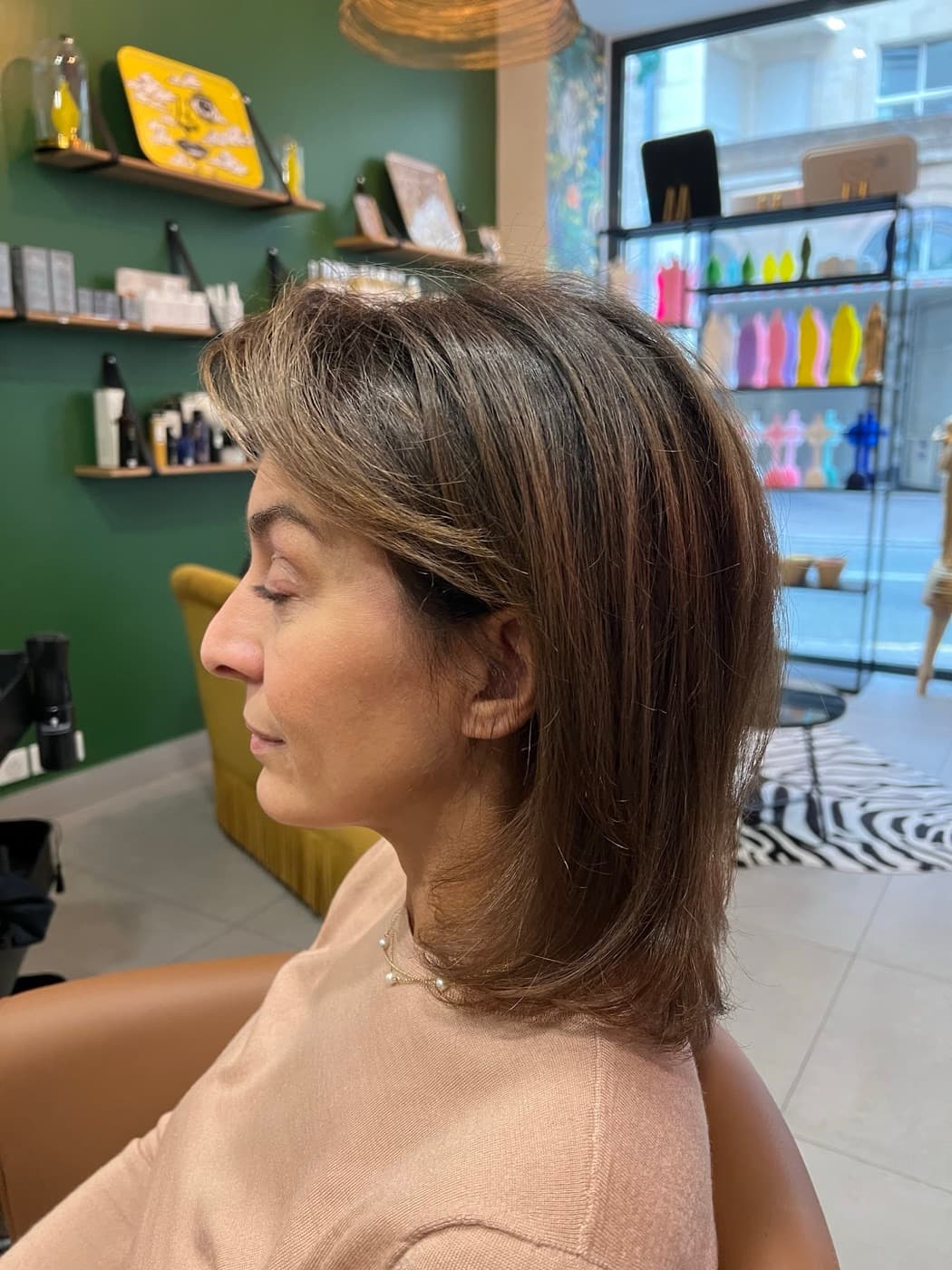 Coupe mi-longue dégradée sur cheveux bruns, de profil